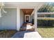 Covered front porch with stone steps and a wood-paneled ceiling, offering a welcoming entrance at 4245 Se 24Th Ter, Ocala, FL 34480