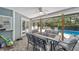 Covered patio boasts brick flooring and ceiling fan over dining table with pool view at 4245 Se 24Th Ter, Ocala, FL 34480