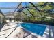 In-ground swimming pool with sun shelf and outdoor seating in screened enclosure at 4245 Se 24Th Ter, Ocala, FL 34480