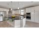 A modern kitchen with stainless steel appliances, a granite island, pendant lighting and white cabinetry at 4546 Nw 53Rd Avenue Rd, Ocala, FL 34482