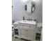 Bright bathroom with a white vanity, marble countertop, and decorative oval mirror at 509 Del Mar Dr, Lady Lake, FL 32159