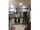 Well-lit kitchen featuring stainless steel appliances, tiled backsplash, and custom shelving at 509 Del Mar Dr, Lady Lake, FL 32159