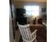 Cozy living room featuring a rocking chair, television, and patterned area rug by the window at 509 Del Mar Dr, Lady Lake, FL 32159
