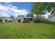 Spacious backyard with a screened in porch, open lawn, and view of the home's exterior at 6385 Sw 61St Ct, Ocala, FL 34474