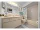 Bright bathroom featuring a vanity, mirror, and a shower with a decorative curtain at 6385 Sw 61St Ct, Ocala, FL 34474