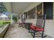 Close-up of an inviting front porch featuring classic rocking chairs with red cushions, perfect for enjoying quiet moments at 6385 Sw 61St Ct, Ocala, FL 34474