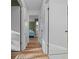 Bright hallway leads to bedroom and bathroom with hard wood floors and neutral paint at 6385 Sw 61St Ct, Ocala, FL 34474