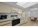 Well lit kitchen with white cabinets, appliances, and an adjacent dining area at 6385 Sw 61St Ct, Ocala, FL 34474