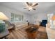 Bright living room showcasing hardwood floors, ceiling fan, and comfortable seating at 6385 Sw 61St Ct, Ocala, FL 34474