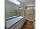 Bright bathroom with wood floors, dual shower, and large vanity mirror at 6767 Sw 114Th Street Rd, Ocala, FL 34476