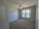 Carpeted bedroom featuring neutral walls, fan, large window, and natural light at 6767 Sw 114Th Street Rd, Ocala, FL 34476