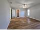 Spacious primary bedroom features wood flooring, a ceiling fan, and a large window at 6767 Sw 114Th Street Rd, Ocala, FL 34476