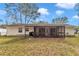 Backyard view showcases the screened-in porch and the property's well-maintained lawn at 736 Ne 26 Ter, Ocala, FL 34470