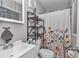 Clean bathroom featuring a floral shower curtain and mirrored medicine cabinet at 736 Ne 26 Ter, Ocala, FL 34470