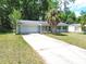 Cozy single-story home with an attached garage, palm tree and a long driveaway providing ample parking space at 736 Ne 26 Ter, Ocala, FL 34470