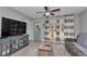 Cozy living room featuring wood flooring, a ceiling fan, and natural light from the windows at 736 Ne 26 Ter, Ocala, FL 34470