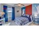 A sporty bedroom with a soccer theme, featuring bold blue and red accents and a cozy plaid bed set at 8658 Sw 44Th Ter, Ocala, FL 34476