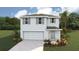 Two-story home featuring a two-car garage, shutters, landscaping, and neutral paint at 8658 Sw 44Th Ter, Ocala, FL 34476