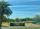 Baseball field with a covered dugout and palm trees, showcasing community recreational facilities and outdoor activities at 9380 Sw 84Th Ter # E, Ocala, FL 34481