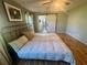 Relaxing bedroom with wood floors, stylish bedding, and barn door to ensuite bath at 9380 Sw 84Th Ter # E, Ocala, FL 34481