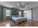 Inviting bedroom with wood floors, ceiling fan, and modern barn door to ensuite bathroom at 9380 Sw 84Th Ter # E, Ocala, FL 34481