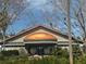 View of a clubhouse with copper cupola, expansive windows, and meticulously kept landscaping at 9380 Sw 84Th Ter # E, Ocala, FL 34481