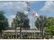 Community area with American flags, palm trees, and a gathering pavilion with picnic tables and benches at 9380 Sw 84Th Ter # E, Ocala, FL 34481