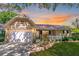 Charming single-story home with attached garage, manicured lawn, and sunset sky at 9380 Sw 84Th Ter # E, Ocala, FL 34481