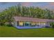 Rear exterior view of home with screened lanai and green backyard at 9380 Sw 84Th Ter # E, Ocala, FL 34481