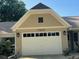 Attached two-car garage with a white door and decorative exterior lights provides secure parking and additional storage space at 9380 Sw 84Th Ter # E, Ocala, FL 34481
