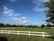 Picturesque golf course view with lush greenery, mature trees, and a pristine white fence at 9380 Sw 84Th Ter # E, Ocala, FL 34481