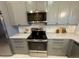 Kitchen with stainless steel appliances, gray cabinets, and granite countertops at 9380 Sw 84Th Ter # E, Ocala, FL 34481