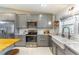 Modern kitchen with stainless steel appliances, stylish cabinetry, and a farmhouse sink under a bright window at 9380 Sw 84Th Ter # E, Ocala, FL 34481