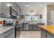 Bright kitchen featuring updated appliances, granite countertops, and a farmhouse sink under a window at 9380 Sw 84Th Ter # E, Ocala, FL 34481