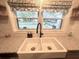Farmhouse sink, black faucet, patterned shade, and view of the neighborhood from the kitchen window at 9380 Sw 84Th Ter # E, Ocala, FL 34481