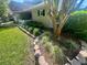 Landscaped yard with decorative stone borders, lush green grass, and established trees for added curb appeal at 9380 Sw 84Th Ter # E, Ocala, FL 34481