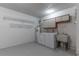 Well-lit laundry room features a washer, dryer, utility sink, and shelving for convenient clothes care at 9380 Sw 84Th Ter # E, Ocala, FL 34481