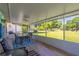 Relaxing screened porch with outdoor dining area overlooking the lush green lawn and trees, perfect for enjoying the outdoors at 9380 Sw 84Th Ter # E, Ocala, FL 34481