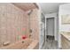 Cozy bathroom featuring a tub with shower, patterned tiles, and ample storage space at 9844 Sw 198Th Cir, Dunnellon, FL 34432