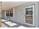 Charming covered front porch with glass front door, decorative lantern and stone accent wall at 9844 Sw 198Th Cir, Dunnellon, FL 34432