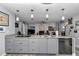 Open kitchen with grey cabinetry, stainless appliances, granite counters and breakfast bar overlooking living room at 9844 Sw 198Th Cir, Dunnellon, FL 34432