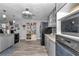 Modern kitchen with stainless steel appliances, grey cabinetry, stone countertops and wood grain laminate flooring at 9844 Sw 198Th Cir, Dunnellon, FL 34432