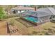 Aerial view of a screened-in pool and surrounding, landscaped yard in a residential setting at 9844 Sw 198Th Cir, Dunnellon, FL 34432