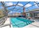 Enclosed pool with clear blue water and ample space for outdoor furniture and entertaining at 9844 Sw 198Th Cir, Dunnellon, FL 34432