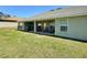 Backyard featuring a covered patio, a grill, ceiling fans, and an expansive grassy area at 1034 Se 65Th Cir, Ocala, FL 34472