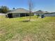 Expansive backyard featuring lush green grass and a charming playset at 1034 Se 65Th Cir, Ocala, FL 34472