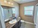 Well-lit bathroom with a shower-tub combo, a vanity with granite countertop and a window at 1034 Se 65Th Cir, Ocala, FL 34472