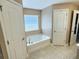 A bathroom features a tub, tile floors, and two doors at 1034 Se 65Th Cir, Ocala, FL 34472