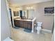 Bathroom featuring tile floors, double sinks, a toilet, and a large mirror at 1034 Se 65Th Cir, Ocala, FL 34472