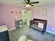 Bedroom with purple walls, carpeted floors, wood crib, ceiling fan and closet at 1034 Se 65Th Cir, Ocala, FL 34472